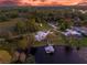 Stunning aerial view of waterfront home with private dock and pool at sunset at 6320 S Sylvan Lake Dr, Sanford, FL 32771