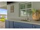 Outdoor kitchen with sink, cabinetry, and lake views at 6320 S Sylvan Lake Dr, Sanford, FL 32771