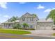 Gray two-story home with white trim, three-car garage, and palm trees at 6320 S Sylvan Lake Dr, Sanford, FL 32771