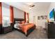 King bedroom with TV, en-suite bathroom, and orange bedding at 4537 Target Blvd, Kissimmee, FL 34746