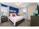 Bedroom with a blue accent wall and comfortable bed at 8896 Cabot Cliffs Dr, Davenport, FL 33896