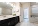 Modern bathroom with double sinks, marble floors, and a soaking tub at 8896 Cabot Cliffs Dr, Davenport, FL 33896