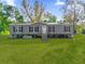 Gray manufactured home with black shutters and wooden steps, on a grassy lot at 18746 Seaford Ave, Orlando, FL 32820