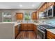Modern kitchen with wood cabinets, stainless steel appliances, and stone backsplash at 41 E Spruce St, Orlando, FL 32804