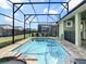 Inviting pool area with screened enclosure, spa, and brick pavers at 1861 Sawyer Palm Pl, Kissimmee, FL 34747