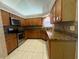 L-shaped kitchen with granite counters and wood cabinets at 2606 Eagles Nest Ct, Orlando, FL 32837