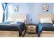 Bedroom with two beds and light blue walls at 4535 Narrative Ln, Kissimmee, FL 34746