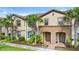 Two-story townhome with palm trees and brick walkway at 1943 Majorca Dr, Kissimmee, FL 34747