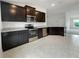 Modern kitchen with dark cabinets, granite countertops, and stainless steel appliances at 4394 Sagefield Dr, Harmony, FL 34773