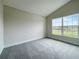 Bright bedroom featuring grey carpet and a large window at 4394 Sagefield Dr, Harmony, FL 34773