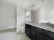 Bathroom with granite countertop, dark cabinets, and shower at 4394 Sagefield Dr, Harmony, FL 34773