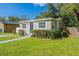 Front view of a tan house with a gray door and walkway at 1506 W 16Th St, Sanford, FL 32771