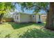 House exterior showcasing a spacious backyard with lush grass and large trees at 1506 W 16Th St, Sanford, FL 32771