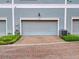 Attached garage with brick driveway and landscaping at 535 Crimson Ln, Winter Springs, FL 32708
