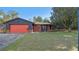 Charming ranch-style home featuring a red garage door and brick accents at 1435 June Ct, Deltona, FL 32725