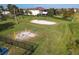 Aerial view of a recreation area with swings, a volleyball court, and a grassy field at 3623 Weatherfield Dr, Kissimmee, FL 34746