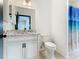 Bathroom with granite countertop, white cabinets, and shower/tub combo at 3623 Weatherfield Dr, Kissimmee, FL 34746