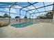 Screened-in pool with patio furniture and umbrella at 1113 Casterton Cir, Davenport, FL 33897