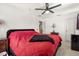 Bedroom with red bedding and a ceiling fan at 348 Sand Ridge Dr, Davenport, FL 33896
