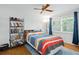 Bedroom with hardwood floors, bookshelf, and colorful bedding at 1681 Blue Ridge Rd, Winter Park, FL 32789