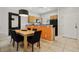 Light wood dining table with four black chairs, located near kitchen at 3004 Bird Of Paradise Ln, Kissimmee, FL 34747