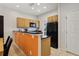 Modern kitchen with wood cabinets, black appliances, and granite counters at 3004 Bird Of Paradise Ln, Kissimmee, FL 34747