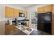 Kitchen with black appliances and wood cabinets at 3004 Bird Of Paradise Ln, Kissimmee, FL 34747