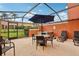 Screened patio with hot tub, table, and chairs at 3004 Bird Of Paradise Ln, Kissimmee, FL 34747