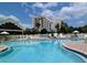Community pool with surrounding lounge chairs and building in background at 6165 Carrier Dr # 2113, Orlando, FL 32819