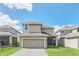 Tan two-story house with a two-car garage at 8795 Ribault Ave, Orlando, FL 32832