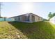 Tan house exterior with covered patio and grassy yard at 207 Goldenrod Ln, Kissimmee, FL 34759