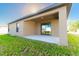 Covered patio with sliding glass doors and grassy backyard at 207 Goldenrod Ln, Kissimmee, FL 34759