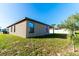 Tan house exterior with a covered patio and grassy backyard at 207 Goldenrod Ln, Kissimmee, FL 34759