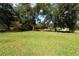 Large backyard with mature trees and grassy area at 7129 Oakwind Dr, Orlando, FL 32818