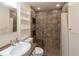 Updated bathroom with walk-in shower, built-in shelving and granite countertop at 7129 Oakwind Dr, Orlando, FL 32818