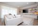 Bright living room featuring a large sectional sofa and built-in shelving with a TV at 5653 Oak Knoll Dr, St Cloud, FL 34771