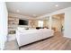 Open living room with sectional sofa, wood-look floors, and access to other rooms at 5653 Oak Knoll Dr, St Cloud, FL 34771