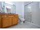Clean bathroom with granite countertop, wood cabinets, and a shower at 8581 Bay Lilly Loop, Kissimmee, FL 34747
