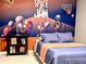 Bedroom with Space Jam mural, full-size bed, and floating shelves at 2104 Fleming Mist Pl, Kissimmee, FL 34747