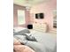 Two twin beds in a pink bedroom with blue and white patterned wallpaper and a TV at 2104 Fleming Mist Pl, Kissimmee, FL 34747