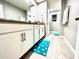 Modern bathroom with white cabinets, teal rug, and a double vanity at 2104 Fleming Mist Pl, Kissimmee, FL 34747