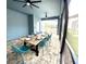 Screened-in patio with a large wooden dining table and teal chairs, overlooking the pool at 2104 Fleming Mist Pl, Kissimmee, FL 34747
