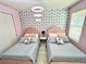 Two twin beds in a pink bedroom with blue and white patterned wallpaper at 2104 Fleming Mist Pl, Kissimmee, FL 34747