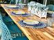 Outdoor patio table setting with blue and yellow plates and a centerpiece of greenery at 2104 Fleming Mist Pl, Kissimmee, FL 34747