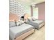 Two twin beds in a pink bedroom with blue and white patterned wallpaper at 2104 Fleming Mist Pl, Kissimmee, FL 34747