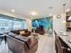 Living room with leather sofas, a large TV, and a stunning ocean mural at 8931 Sydney Ave, Kissimmee, FL 34747