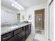 Bathroom with granite countertops, double sinks, and a walk-in shower at 8931 Sydney Ave, Kissimmee, FL 34747