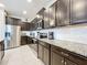 Modern kitchen with dark wood cabinets, granite countertops, and stainless steel appliances at 8931 Sydney Ave, Kissimmee, FL 34747