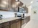 Modern kitchen with dark cabinets, granite counters, and stainless steel appliances at 8931 Sydney Ave, Kissimmee, FL 34747
