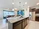 Kitchen island with granite countertop, sink, and dark wood cabinets at 8931 Sydney Ave, Kissimmee, FL 34747